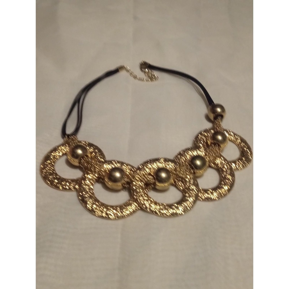 Statement necklace w a black cord and gold-toned, abstract Circular-shaped link